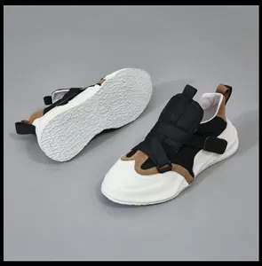 Detail van leren herensneakers met klittenbandsluiting en dikke witte profielzolen