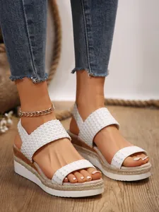 Primer plano de sandalias de cuña blancas con plataforma para un estilo de playa
