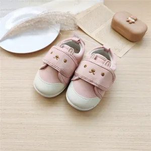 Vue de dessus de chaussures de marche roses pour bébé avec semelles souples et velcro