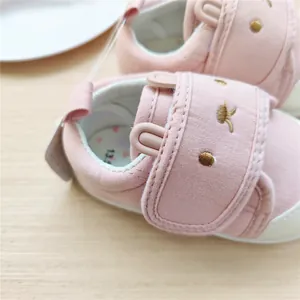 Gros plan d'une chaussure de bébé rose avec une broderie de lapin mignonne