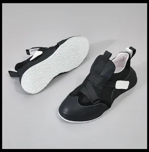 Gedetailleerd zijaanzicht en witte getextureerde zool van zwarte heren sneakers van leer.