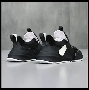 Achteraanzicht van stijlvolle zwart echt lederen sneakers met wit klittenband en dikke zool