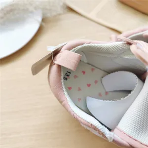 Vue détaillée de l'intérieur d'une chaussure bébé rose avec l'étiquette de taille 13,5