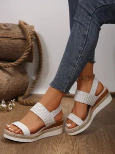 Primer plano de sandalias de cuña blancas tejidas para mujer en estilo rústico