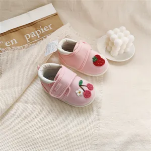 Close-up of pink baby shoes with detailed strawberry and cherry fruit embroidery