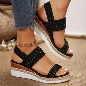 Elegantes sandalias de cuña negras para mujer con tiras tejidas y suela de plataforma de yute