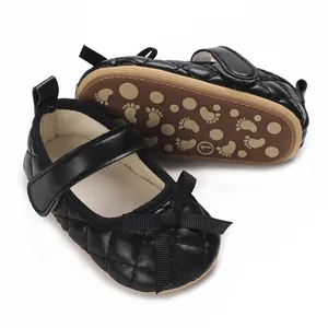 Detalle de zapatos de bebé acolchados negros con lazo y suela suave antideslizante