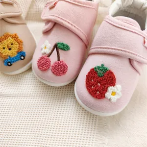 Detailed macro view of embroidered cherry and strawberry patterns on baby soft-sole shoes