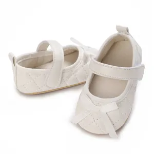 Detalle de zapatos de gateo blancos acolchados para bebé con lazo y suela blanda