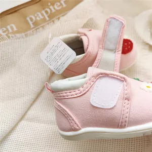 Close-up detail of pink embroidered canvas baby walking shoes with soft soles and velcro strap