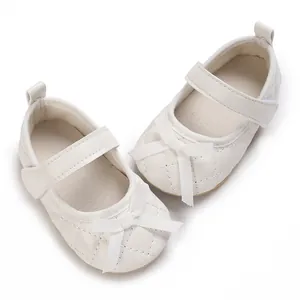 Primer plano de zapatos blancos acolchados para bebé con lazo y cierre de velcro