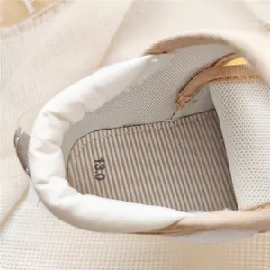 Detail view of breathable interior lining and striped insole of baby soft sole walking shoes