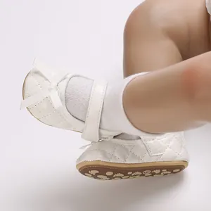 Vista detallada de zapatos blancos acolchados para bebé con lazo y suela suave