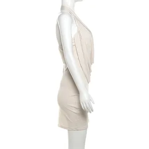 Vue latérale détaillée d'une robe moulante beige sexy à dos nu et licou sur un mannequin blanc.