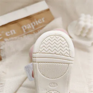 Close-up detail of white anti-slip soft sole for baby walking shoes with size 13.0 mark