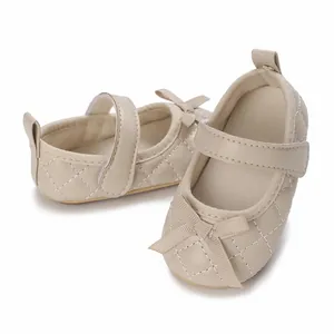 Vista detallada de los zapatos de bebé acolchados beige para niña con detalle de lazo