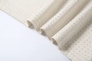 Vue détaillée de strass argentés scintillants sur le tissu d'une robe beige sexy.