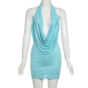 Gros plan d'une robe dos nu à paillettes bleu clair sur un mannequin blanc de studio