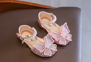 Detail view of pink girls' princess sandals with rhinestone butterfly and pearls