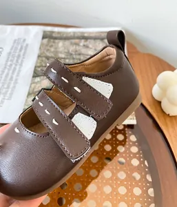 Primer plano de zapatos de princesa para bebé marrón con bordado de corazón