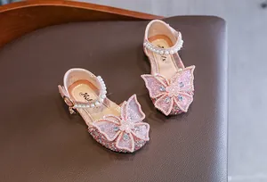 Detailed macro view of pink princess shoes featuring a large butterfly and pearls.