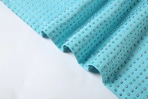 Détail macro du tissu de robe bleu clair avec des embellissements de micro-clous argentés