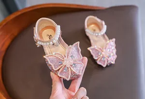 Close-up of pink girls princess shoes with sparkling butterfly and pearl details
