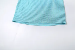 Détail d'une robe moulante turquoise avec des strass argentés brillants et scintillants.
