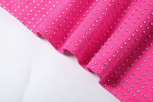 Gros plan du tissu rose vif orné de strass argentés et de doubles coutures fines