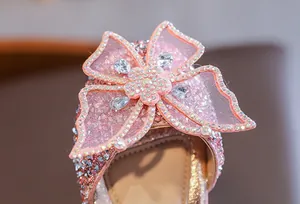 Close-up of pink sparkly bow with rhinestones on girl's princess dance party shoe