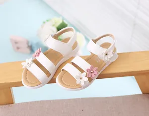 Primer plano de sandalias blancas para niñas con delicadas flores rosas y blancas