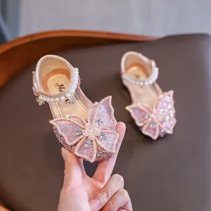 Sparkling pink girls' princess sandals featuring large butterfly bows and pearl straps