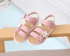 Primer plano de sandalias rosas para niña con flores en 3D y suela de goma blanca resistente