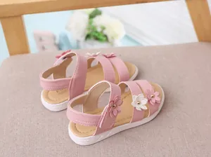 Primer plano de sandalias rosas para niña con detalles florales en relieve