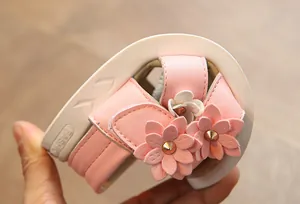 Close-up showing the flexible soft sole of pink flower sandals for girls