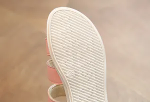 Macro detail of white anti-slip sole on pink girl's sandal with size 28 mark