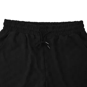 Detailed view of the black embossed checkered texture and drawstring on men's relaxed shorts