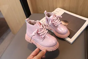 Close-up detail of stylish pink glitter Martin boots for kids featuring side zipper