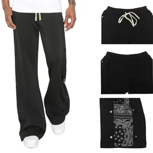 Détails du pantalon de sport large pour homme avec boutons-pression latéraux et imprimé cachemire.
