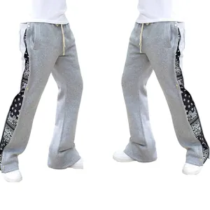Vue détaillée du pantalon de jogging gris avec panneaux paisley et boutons-pression.