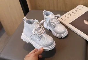 Detail shot of silver glittery children's Martin boots with white lace-up design