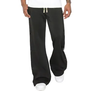 Détail du pantalon noir homme high street avec boutons-pression latéraux et motif paisley