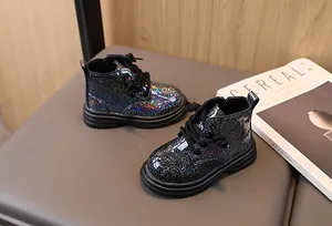 Detail view of sparkly black glitter Martin boots for children with lace-up design