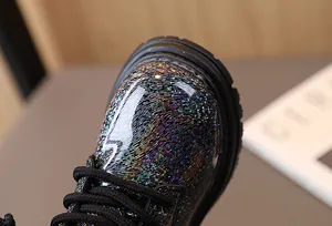 Detailed view of children's Martin boots with colorful holographic glossy leather texture
