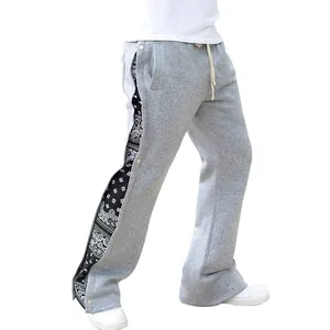 Détail du jogging gris pour homme avec boutons-pression latéraux et motif paisley noir.