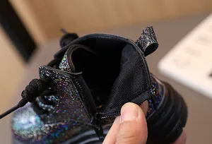 Close-up detail of zipper and lining on glittery holographic kids' Martin boots.