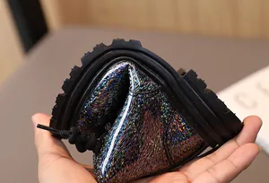 Detailed close-up showing the extreme flexibility and soft sole of glittery children's boots