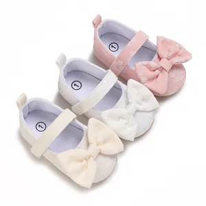 Detailansicht von Baby-Lauflernschuhen mit Schleife in Rosa, Weiß und Creme.