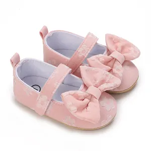 Detailaufnahme von rosa Baby Mädchen Blumenschuhen mit einer großen Zierschleife