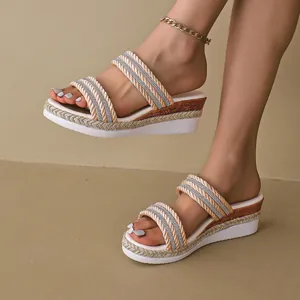 Primo piano di sandali con zeppa alla moda con cinturini intrecciati e strass chiari